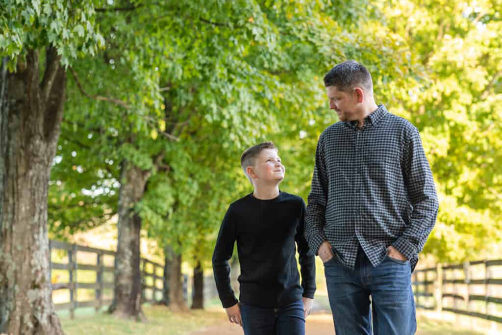 10 year old son looks up at his dad as they take a walk